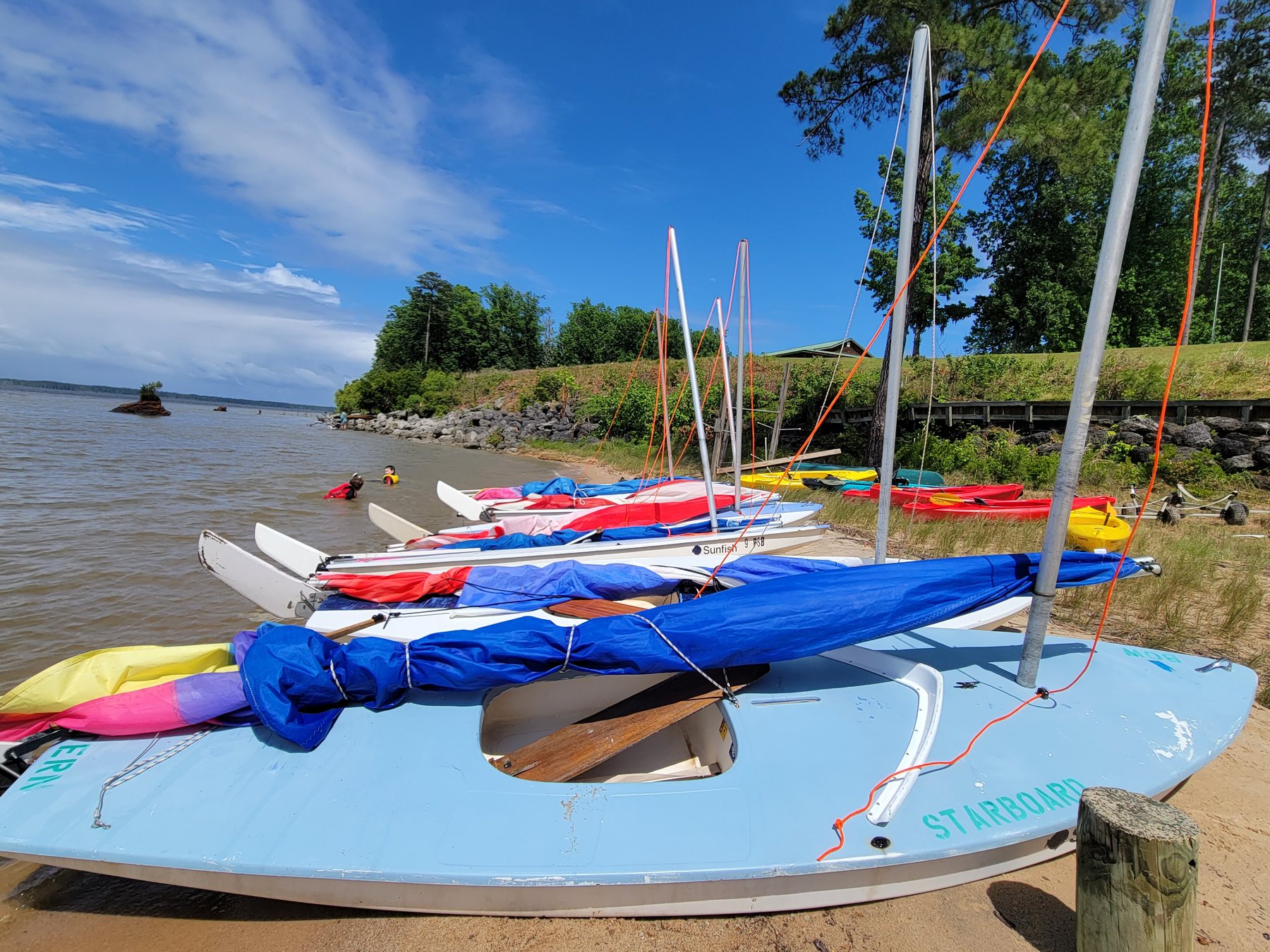 Sunfish sailboats rigged on the beach for a day of instruction